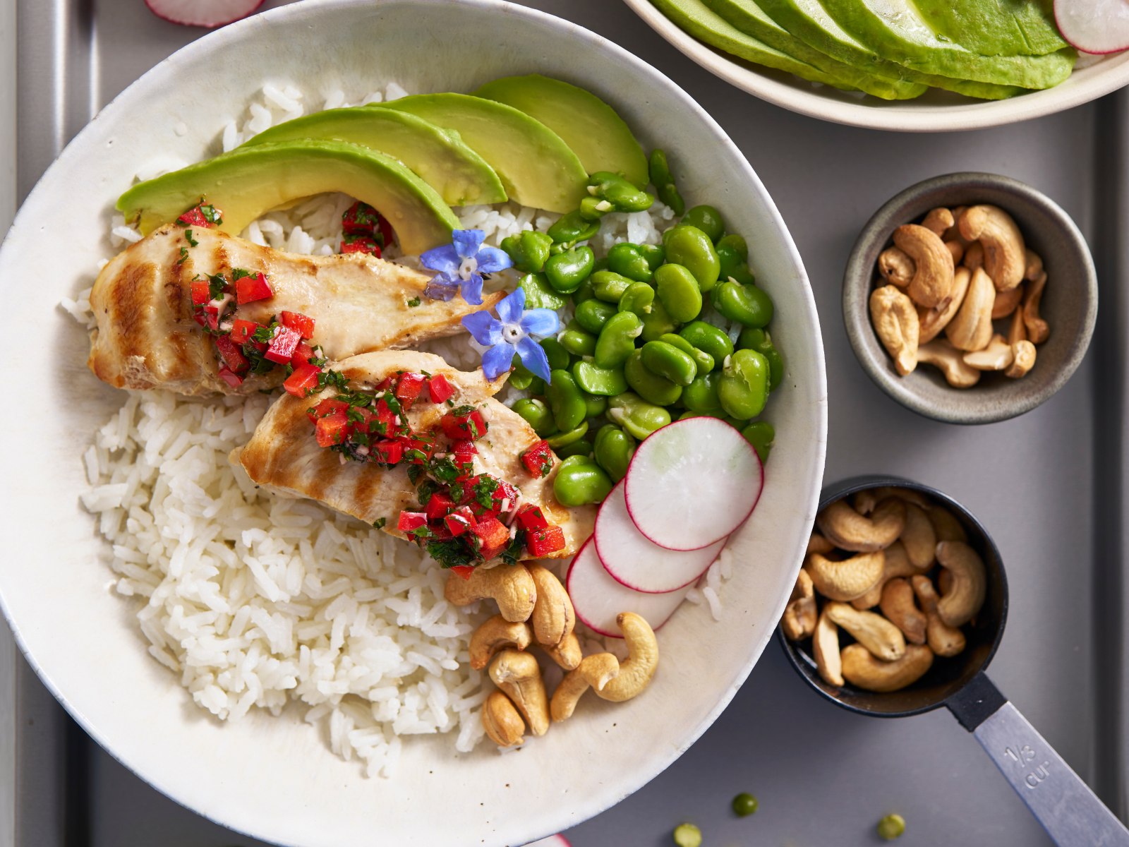 imagem de bowls de frango, arroz, edamame, abacate, rabanetes e molho chimichurri 
